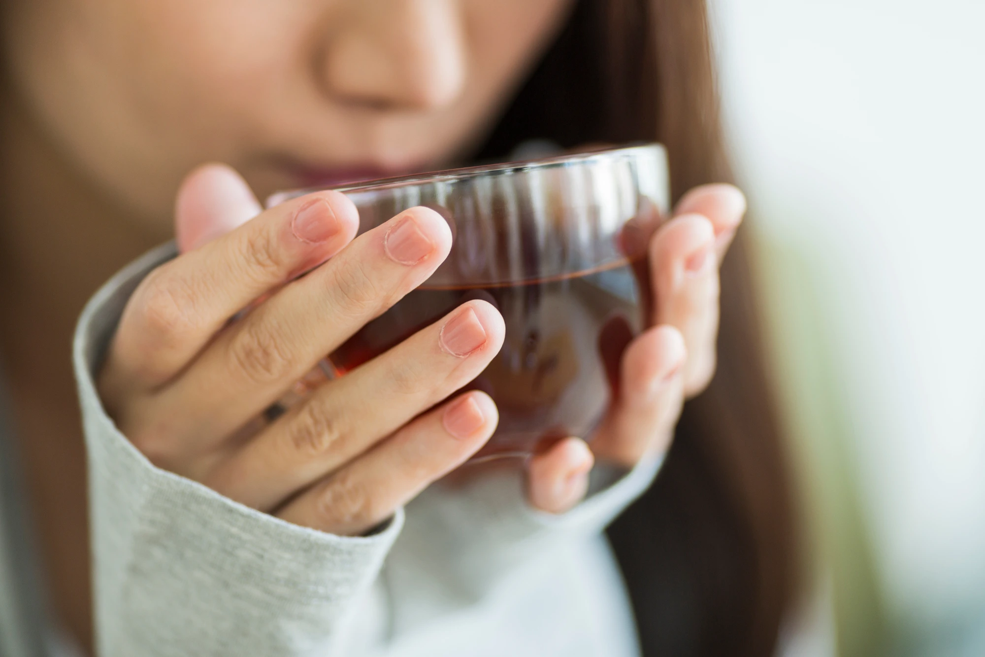 温かいお茶を飲み身体を温める女性