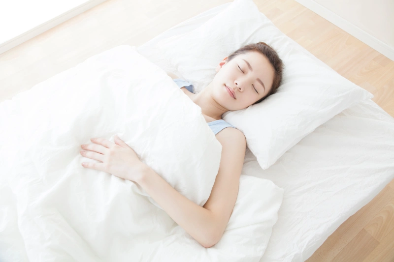 高い枕で睡眠をとる女性